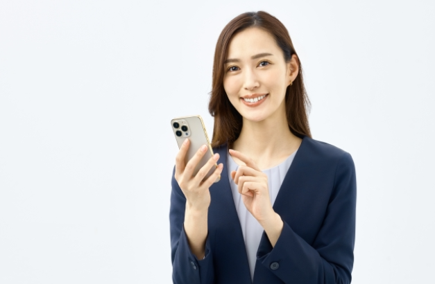 スマートフォンを操作するビジネススーツ姿の女性