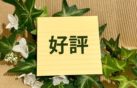 “好評”の文字が書かれた黄色いメモと葉