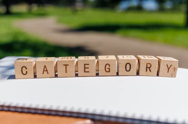 CATEGORYの文字が書かれた木製ブロックがノートの上に並んでいる