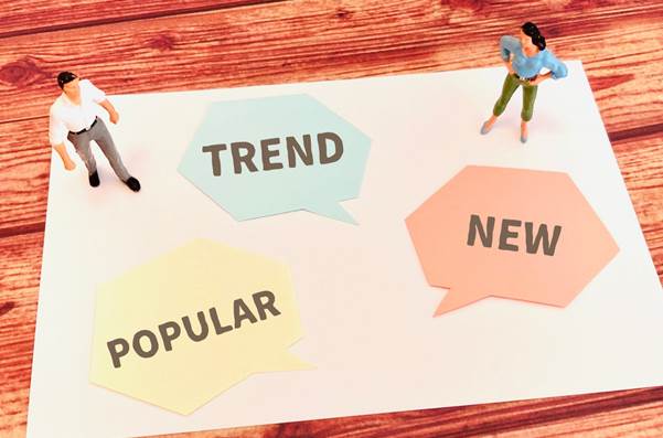TREND・NEW・POPULARと書かれた吹き出しと2体のフィギュア